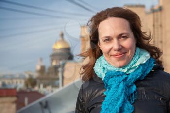 Outdoor portrait of young smiling Caucasian woman on the roof in St.Petersburg, Russia
