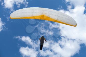 Paraglider in the blue sky with clouds