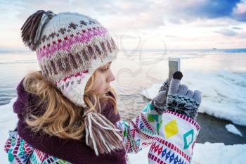 Little blond Caucasian girl taking pictures on her smartphone photo camera