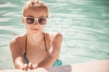 Little blond girl with sunglasses, closeup portrait, vintage toned photo filter effect