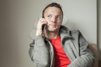 Portrait of young adult Caucasian man talking on mobile phone