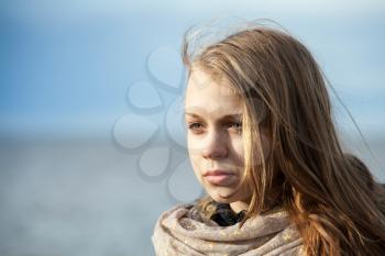 Closeup outdoor portrait of beautiful blond Caucasian teenage girl on a Sea coast with natural light