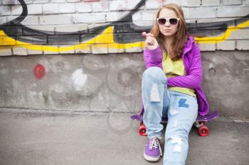 Blond teenage girl with lollipop, urban outdoor portrait