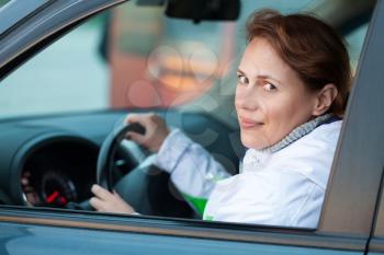 Young Caucasian woman as a driver in a car, outdoor closeup portrait