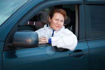 Young Caucasian woman as a driver in a big car, outdoor portrait