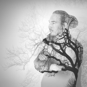 Portrait of young Asian man combined with bare tree landscape, double exposure photo effect