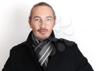 Closeup studio portrait of young Asian man in black coat and woolen scarf over white wall background