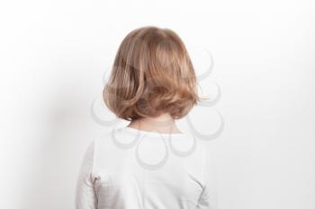Little blond Caucasian girl back over white background, studio portrait