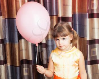Portrait of Caucasian blond little girl with pink balloon
