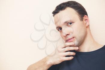 oung thinking Caucasian man studio portrait over gray wall background