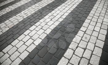 Pedestrian crossing with road marking: white rectangles on gray granite cobblestone road