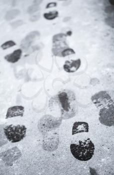 Footsteps in wet snow on asphalt urban road