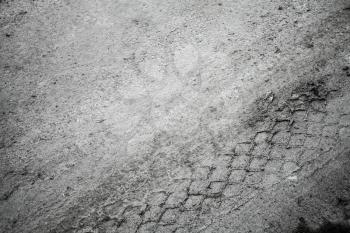 Abstract traffic background. Close-up view of tires tracks on the road dirt