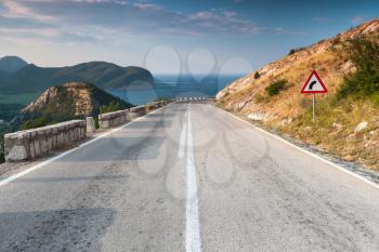 Dividing line and right turn sign on the coastal mountain highway. Montenegro