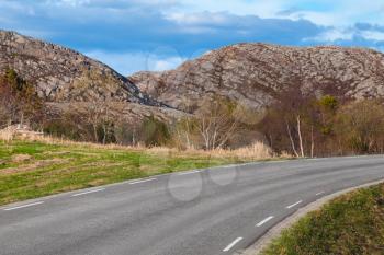 Turning asphalt road in Norway, spring season