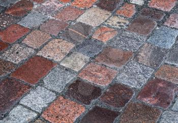 Background texture of old wet granite cobblestone road