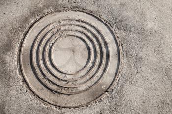 Round sewer manhole on urban asphalt road