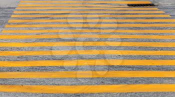Pedestrian crossing road marking with yellow stripes on asphalt