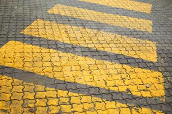 Pedestrian crossing, yellow marking on cobblestone road pavement