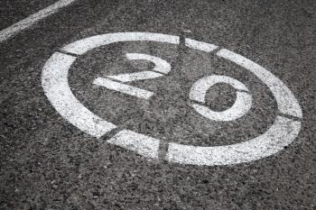 Speed limit road sign on gray asphalt