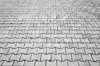 Abstract urban background texture of modern gray cobblestone road pavement with perspective effect