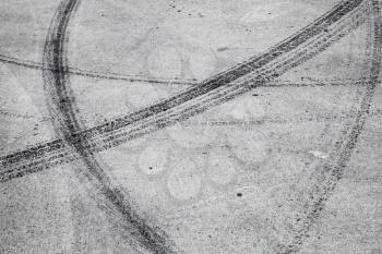 Abstract transportation background with tire tracks on gray asphalt road