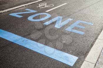 Road marking with blue text zone, stop line and bicycle sign