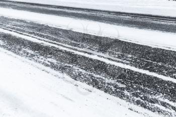 Winter slippery road background photo, asphalt pavement under fresh snow layer