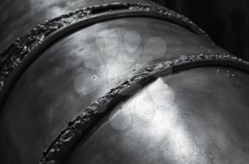 Black shining metal surface with weld seams, close-up photo with selective focus