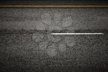 Road marking: white and yellow lines on the dark asphalt road