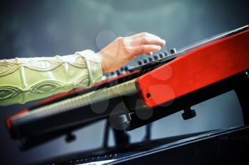Pop music. Electric piano player hand and keyboard, closeup photo with selective focus