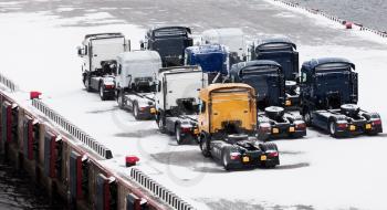 Trucks waits on snowbound pier in port