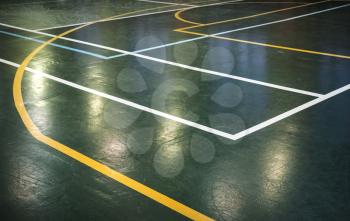 Green shining floor of sports hall with marking lines