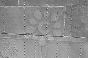 Old gray metal wall with rivets, vintage ship hull background texture