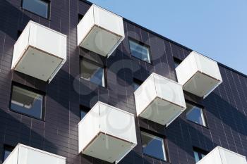 Abstract fragment of contemporary architecture, cube shaped balconies with white matte glass railings