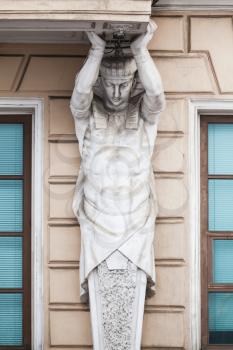 Atlas as decorative column of the facade of an old classical building in Saint-Petersburg, Russia