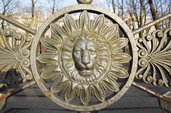 Front view of lion head in round frame. Decoration of old metal fence in central historical part of Saint-Petersburg, Russia