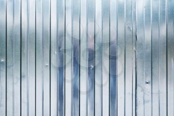 New shining corrugated metal fence, industrial wall background photo texture
