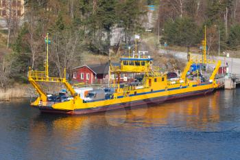 Yellow Ro-Ro cargo ship loading. Small pier near Stockholm, Sweden