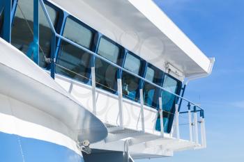 Modern passenger ferry ship. Captains bridge exterior over clear blue sky