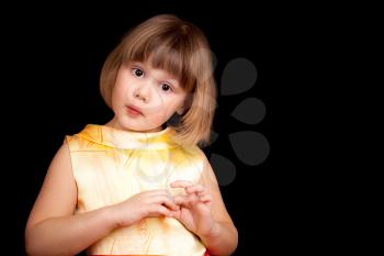 Studio portrait of funny little Caucasian blond girl on black background