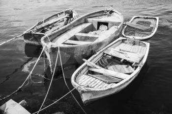 Old wooden fishing boats moored in small port of Avcilar, district of Istanbul, Turkey. Black and white retro stylized photo