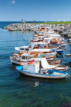 Vertical photo of colorful wooden fishing boats moored in small port of Avcilar, district of Istanbul, Turkey