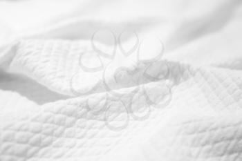 White cotton fabric texture, crumpled blanket, background photo with selective focus