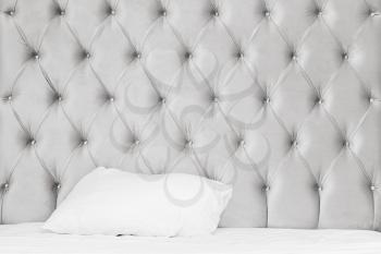 Luxury empty bedroom interior fragment, soft bed wall, white bedding sheet and pillow