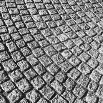 Dark gray cobblestone street pavement with round pattern, urban background texture