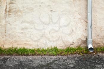 Abstract empty urban background, old house wall with downspout near asphalt road