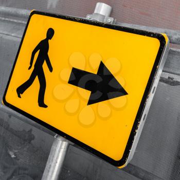 Pedestrians bypass direction. Yellow road sign close up photo