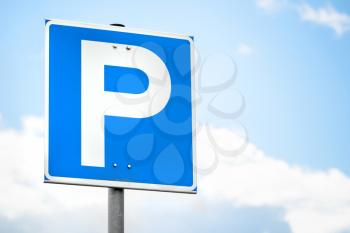 Blue square parking road sign over bright sky background