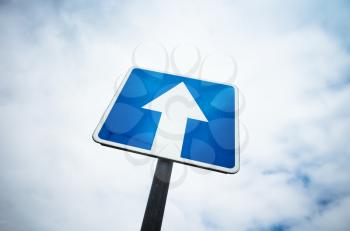 One way street, square blue road sign over cloudy sky background